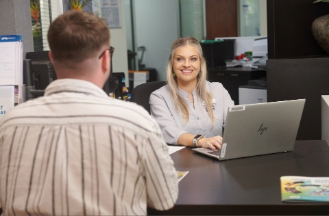 Customer speaking to woman at a desk